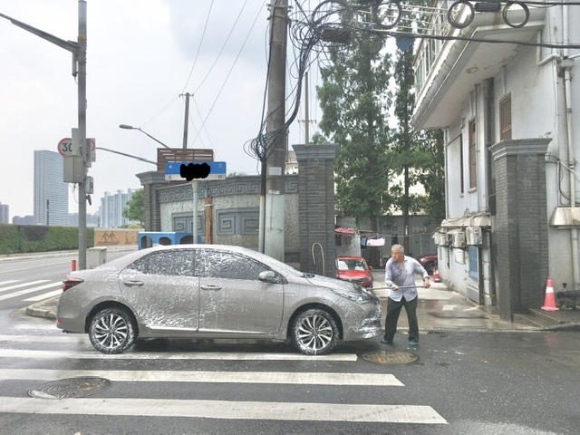 Shanghai, An old man, heritage architecture and car washing